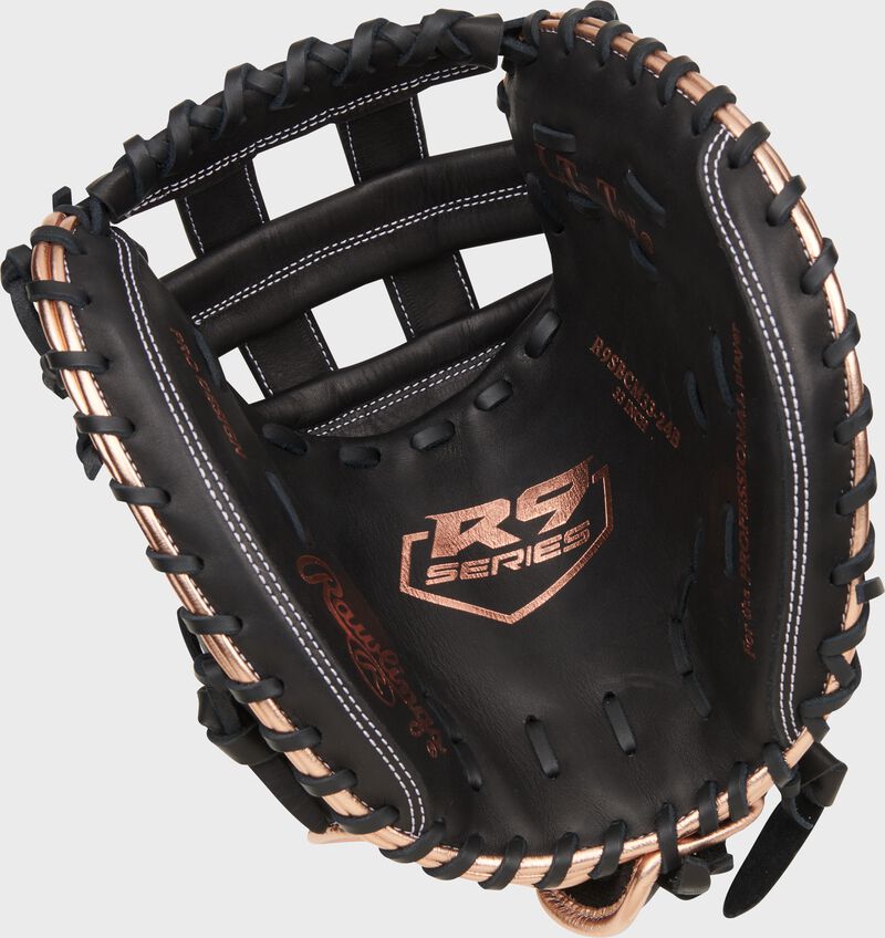 Black palm of a Rawlings R9 Series fastpitch catcher's mitt with rose gold stamping and black laces loading=
