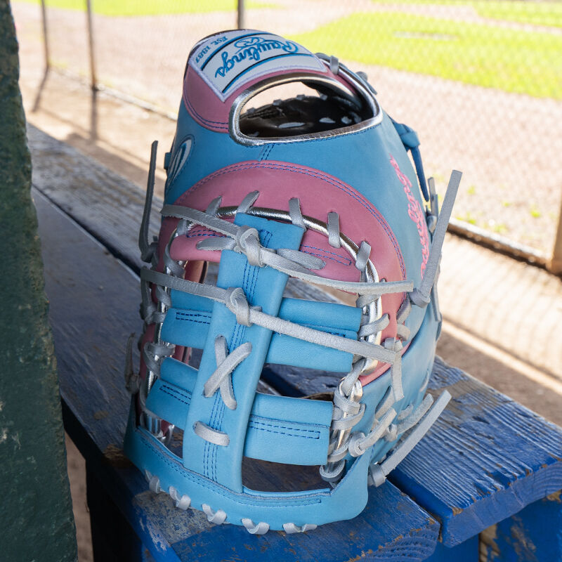 Picture of the web of a columbia blue/pink Exclusive Heart of the Hide 13-Inch 1st Base Mitt standing on its fingertips