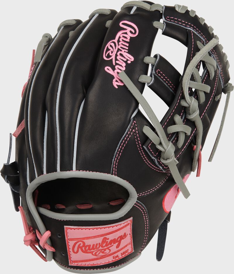 Back of a black Rawlings Heart of the Hide Broken Heart 11.5" glove with a pink Rawlings patch