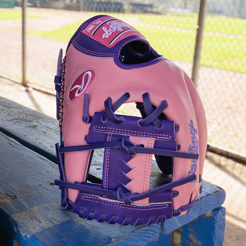 Picture of a Rawlings exclusive 11.5" R2G Heart of the Hide pink/purple infield glove standing on its fingertips on a table