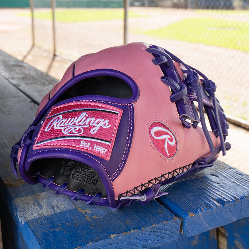 Picture of a Rawlings exclusive 11.5" R2G Heart of the Hide pink/purple infield glove on a table