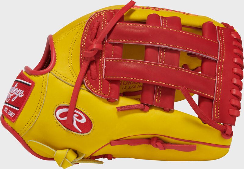 Thumb of a yellow/red Ronald Acuna Jr. Heart of the Hide outfield glove with a red H-web