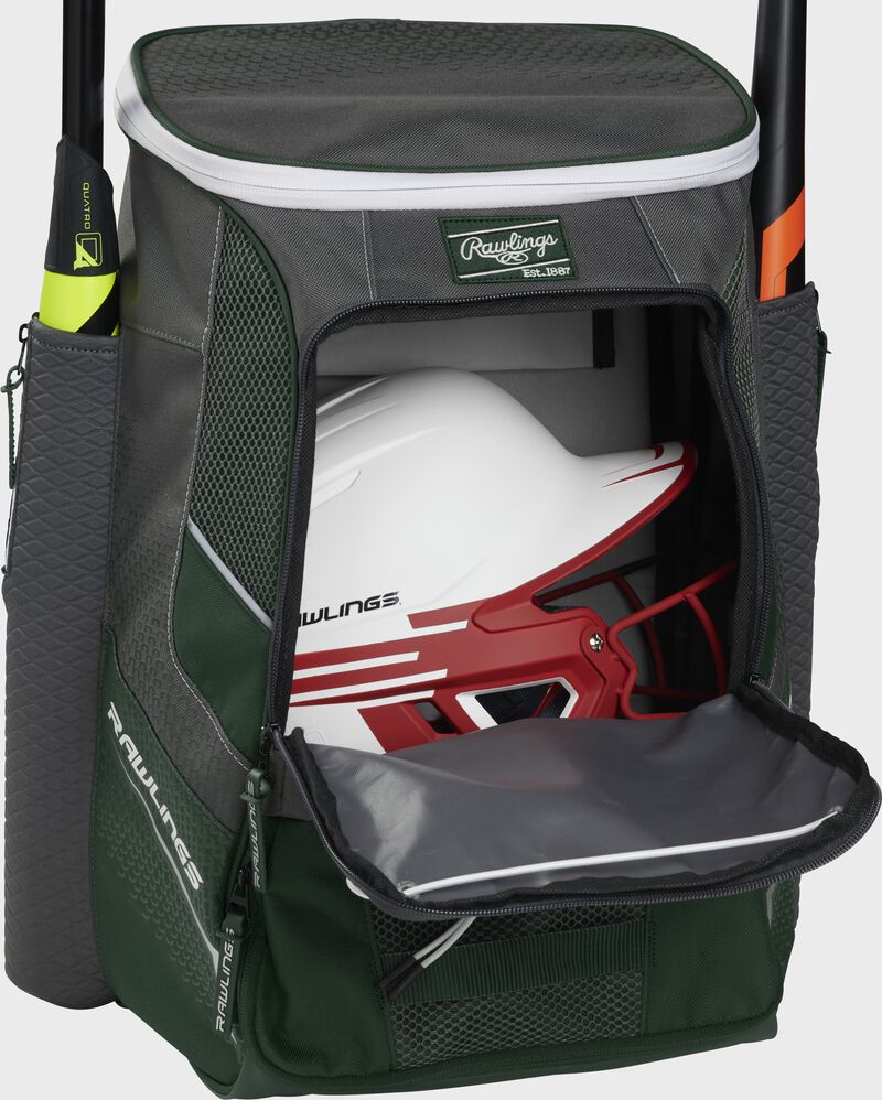 A dark green Impulse baseball backpack with a helmet in the main compartment - SKU: IMPLSE-DG