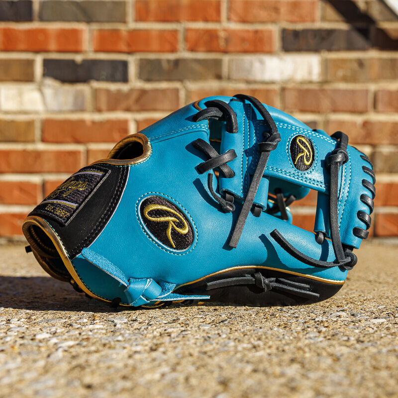 Picture of a teal Exclusive 11.5" Rawlings R2G Heart of the Hide infield glove in front of a brick wall