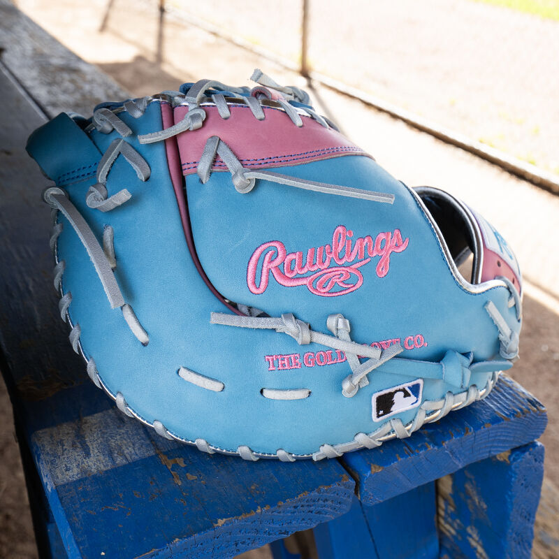 Picture of the back of a columbia blue/pink Exclusive Heart of the Hide 13-Inch 1st Base Mitt on a table