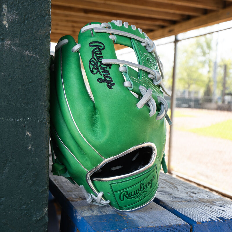 Picture of the back of a Rawlings exclusive 11.5" R2G Heart of the Hide Kelly Green glove leaned against a wall