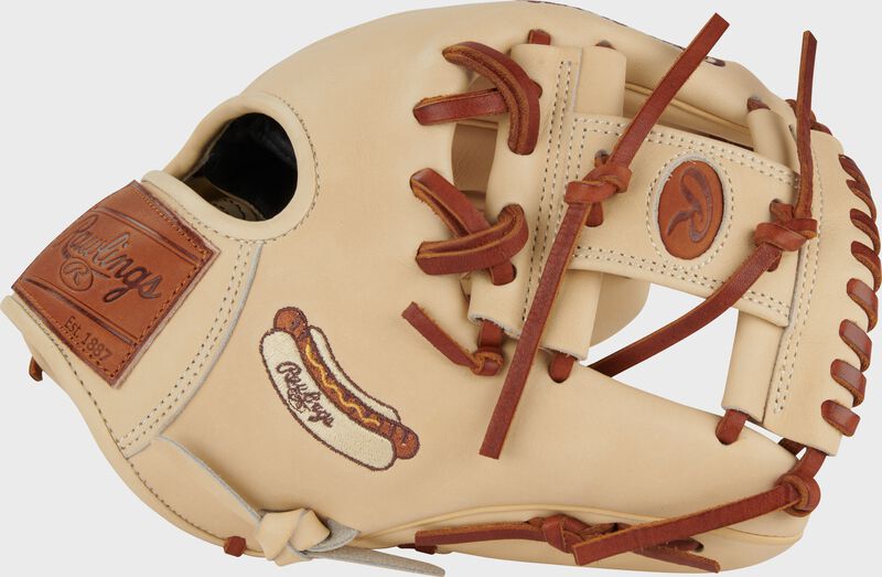 Thumb of a camel exclusive Heart of the Hide Hot Dog infield glove with a Rawlings Hot Dog embroidered on the thumb loading=