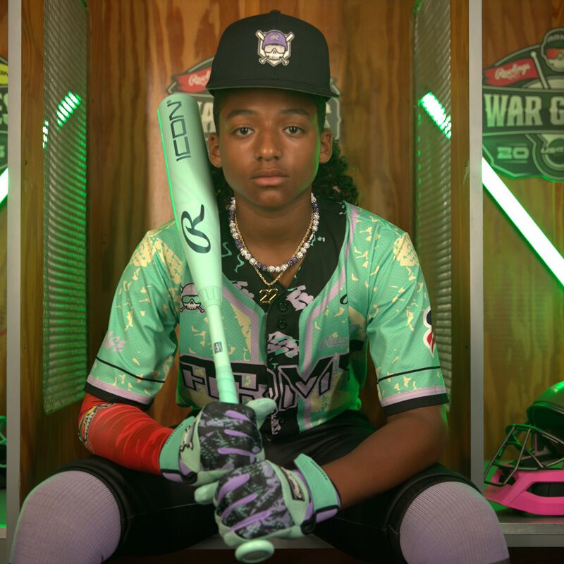 Picture of a player sitting on a bench with a 2026 Rawlings Icon USSSA baseball bat loading=