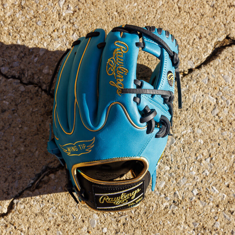 Picture of a teal/black Exclusive 11.5" Rawlings R2G Heart of the Hide infield glove from above on cement