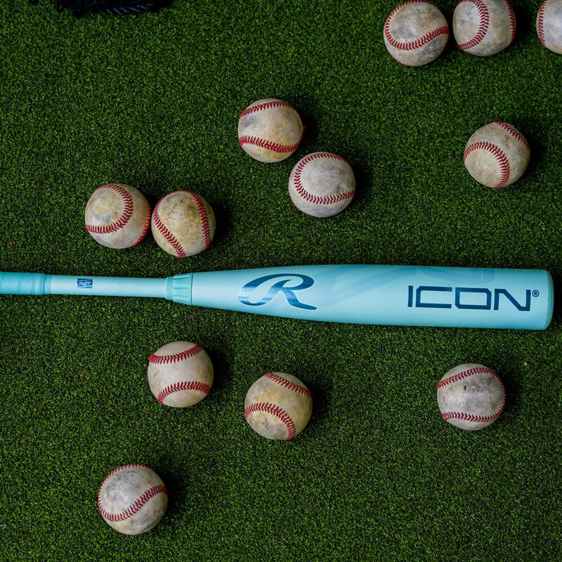 A 2026 Rawlings Icon BBCOR bat on the ground surrounded by baseballs loading=