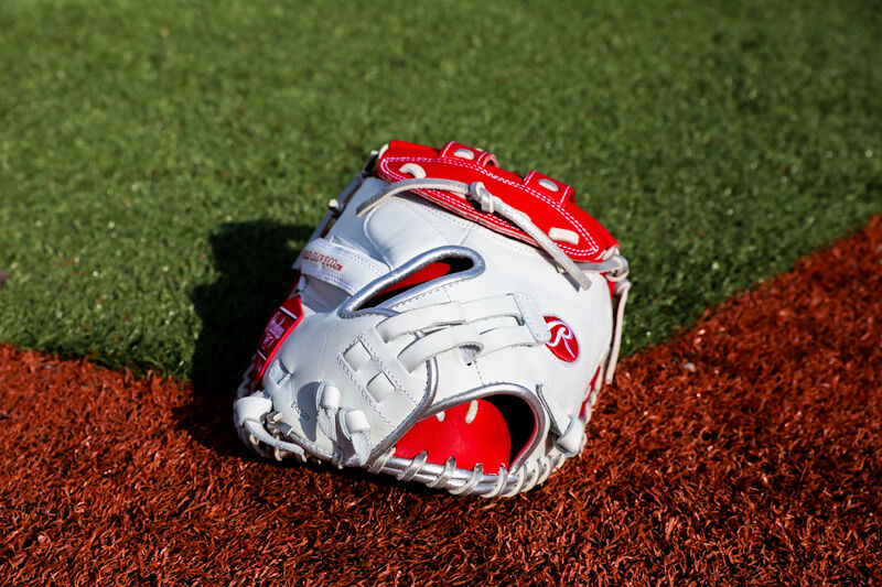 Back of a white/scarlet Liberty Advanced Color Series catcher's mitt on a field - SKU: RLACM34FPWSP loading=