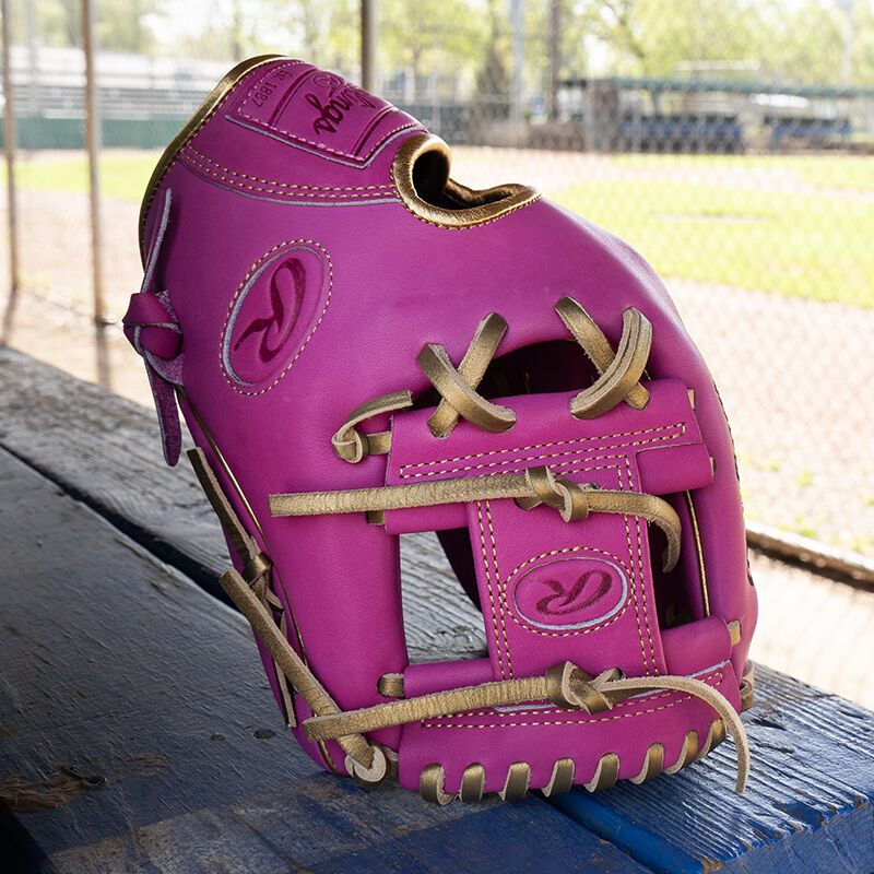 An Exclusive 11.5" R2G Heart of the Hide Berry infield glove on it's fingertips on a bench