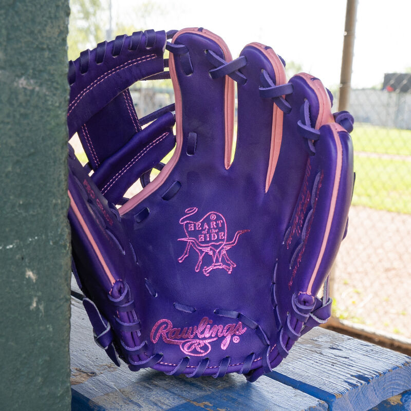 Picture of the palm of a Rawlings exclusive 11.5" R2G Heart of the Hide pink/purple infield glove leaned against a wall