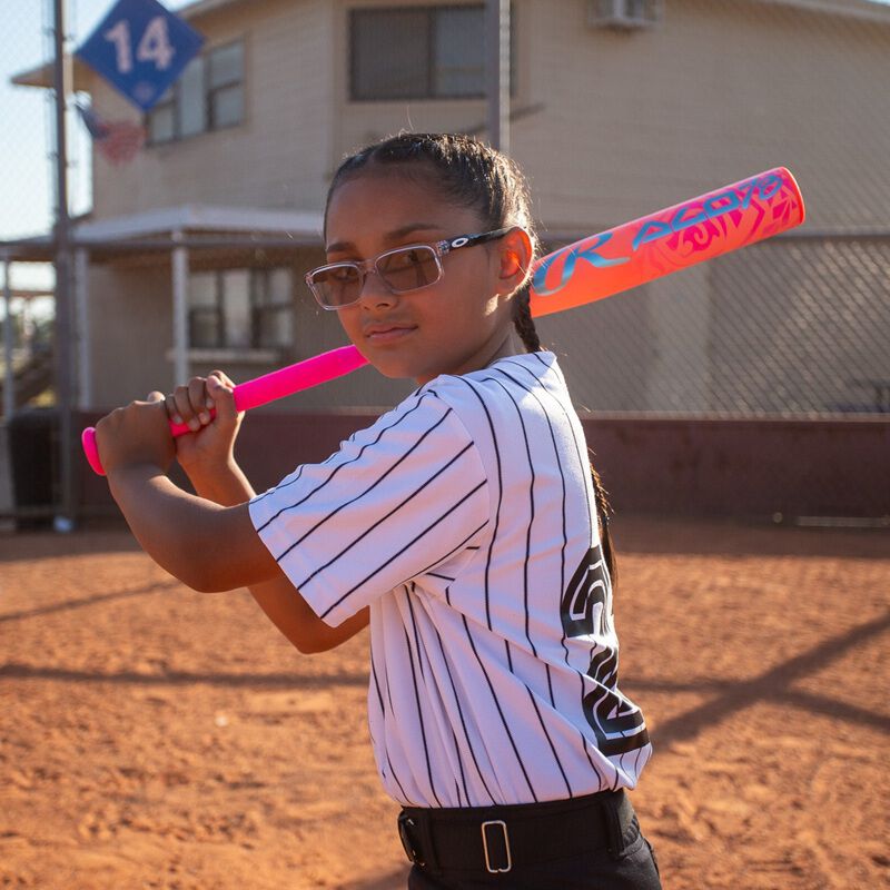 A girl standing in her batting stance with a pink Rawlings ALO78 -12 fastpitch softball bat