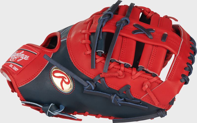 Thumb of a navy/scarlet Gameday 57 Series Vladimir Guerrero Pro Preferred 1st base mitt with a gold Oval-R on the thumb