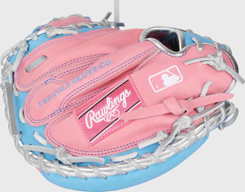 Pink back of a Heart of the Hide 32.5" catcher's mitt with a pink Rawlings patch and MLB logo on the pinky