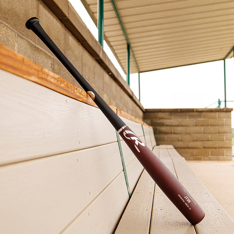 A maroon/black Pro Preferred JT39 Torpedo barrel birch wood bat leaning against a wall loading=