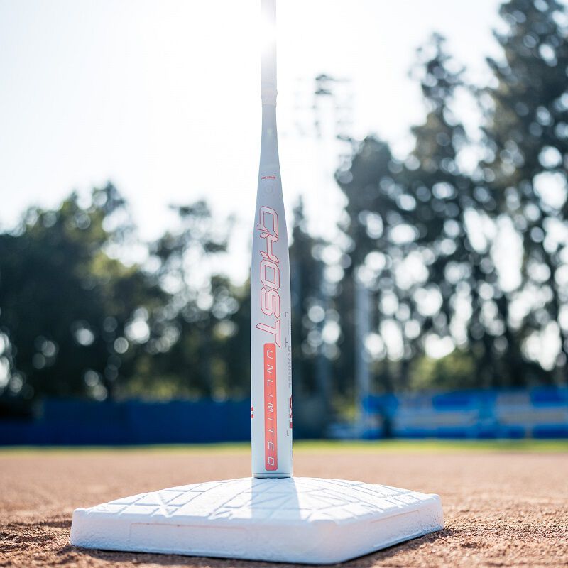 A 2025 Easton Ghost Unlimited fastpitch bat standing on its end on top of a base