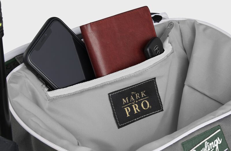 Zippered pocket in the top storage compartment of a dark green Impulse backpack with a phone, wallet and keys - SKU: IMPLSE-DG