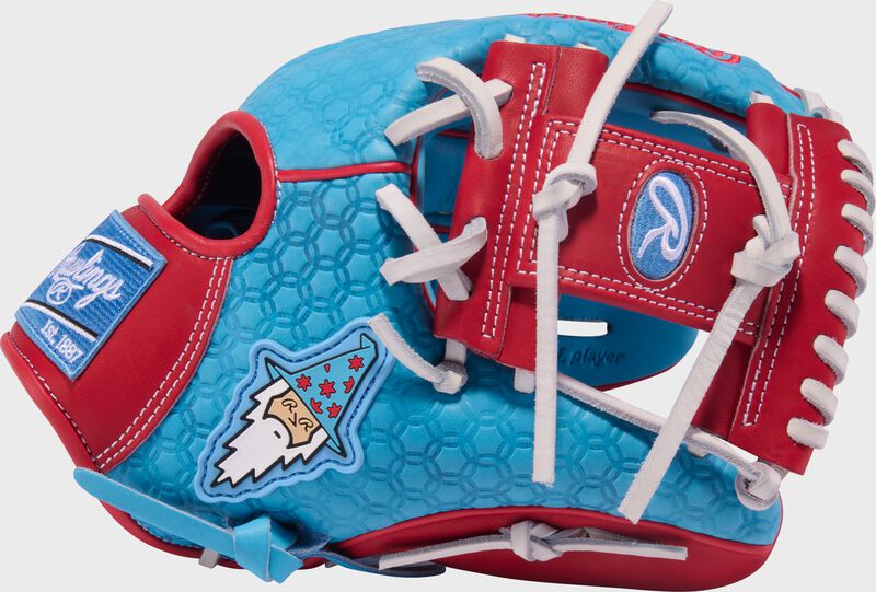 Thumb of a Columbia blue Rawlings x Bettinardi Heart of the Hide 11.75" infield glove with the Bettinardi Wizard on the thumb and a scarlet I-web