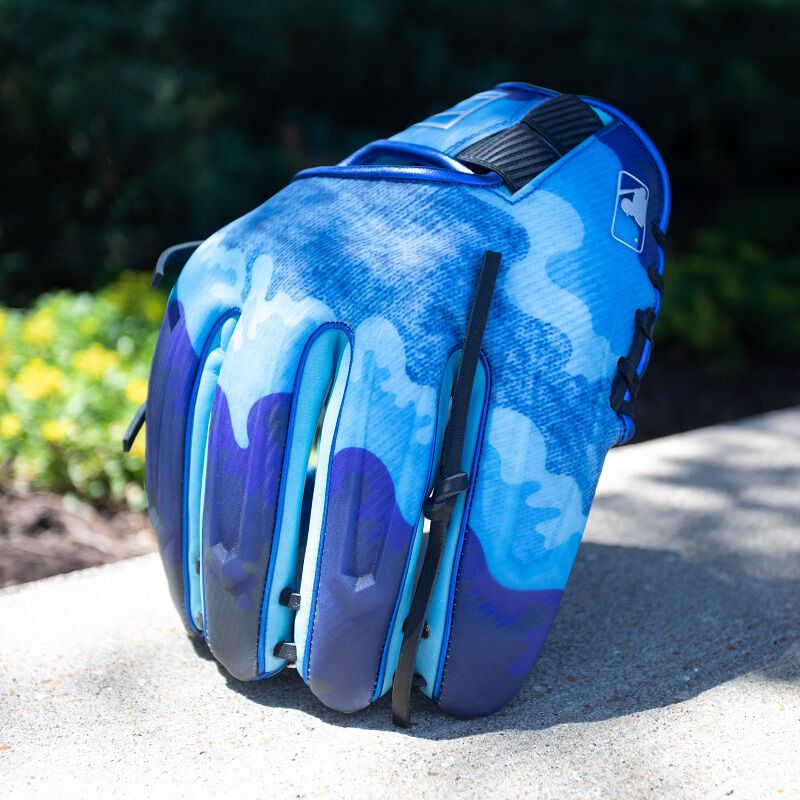 Picture of the back of a blue REV1X Father's day glove standing on its fingers on concrete